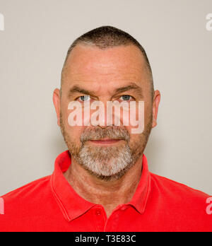 Close up cropped portrait of an Friendly bearded middle-aged man over a studio background Stock Photo