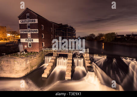 Castleford Millennium Bridge with Castleford Stoneground Flour building in West Yorkshire at Night time with the flour mill to the left.  Landscape. Stock Photo