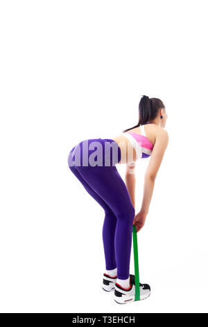 Sporty woman does  exercises and stretch on legs and buttons  with sport fitness rubber bands  on white background. Photo of muscular woman in sportsw Stock Photo