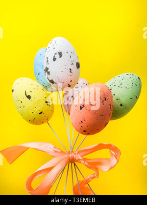 Easter holiday background. Pastel coloured decorated easter eggs on yellow background. copy space Stock Photo