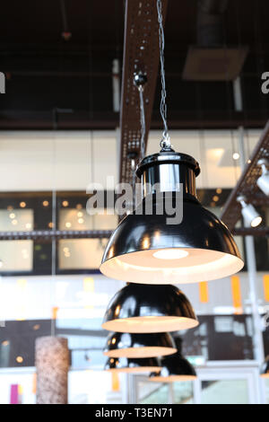 Row of black stylish electric lamps in the cafe. Interior design. Stock Photo