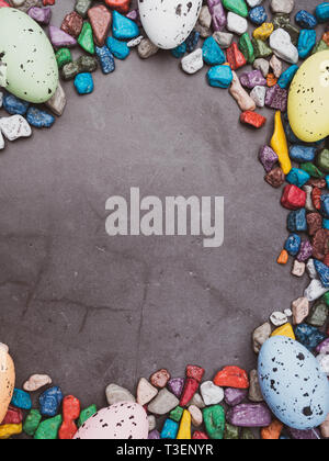 Easter composition with colored eggs, sweets on concreten background, space for text, springtime postcard, greeting card Stock Photo