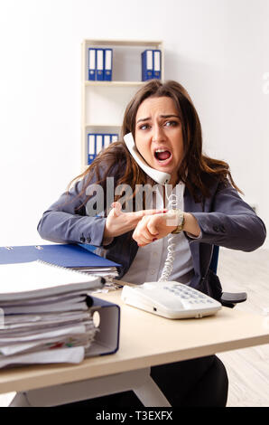 Young female employee unhappy with excessive work Stock Photo