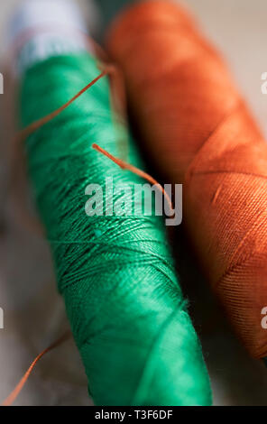Orange and green thread used for sewing Stock Photo