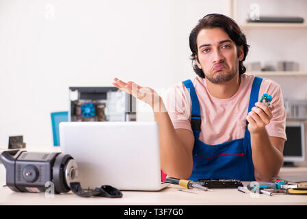 Young male contractor repairing computer Stock Photo