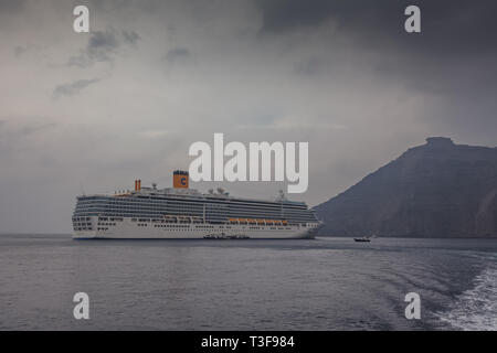 SANTORINI GREECE - OCTOBER 24 2018: Cruise ship stops in the bay on a rainy day Stock Photo