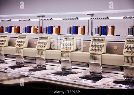 Automatic Embroidery Machines in process on the factory. 9 Needle Compact Embroidery Machine. Stock Photo