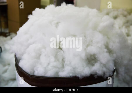 Modern bio-polymeric synthetic filler  for fabric toys on toy factory. White synthetic fabrics textured background.  It is alternative down Stock Photo