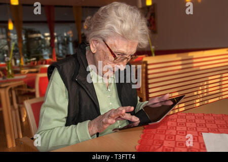 Senior woman typing on tablet computer Stock Photo