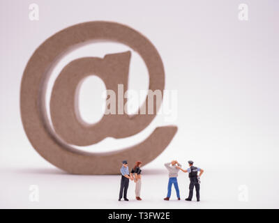 Miniatur police arresting cyber criminal Stock Photo