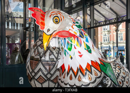 Preston, Lancashire. UK 9th April 2019. Giant Easter chickens on display in the city centre. Papier-Mache giant cockerel Easter festive figures on display. Standing at two-metres tall, the attractions are to be placed outside Preston Market. Keith Ogden, a local artist, is the man behind the hand painted attraction. The eggs are themed around the the city's industrial heritage and Lancashire landscapes. Preston Markets are to exhibit the Giant Easter Eggs for selfie competition over the Easter holidays. Stock Photo