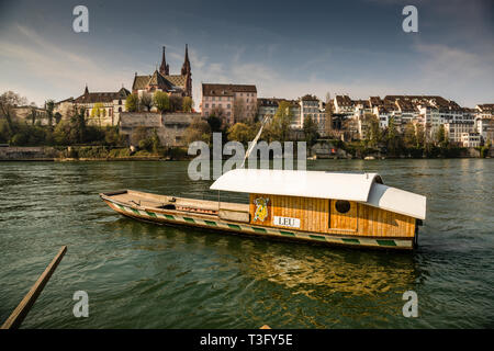 The Basel Rhine ferry 'Leu' at the cathedral. In the midday hours, people like to cross to the other side for lunch, which is then in the sun. A crossing costs 1.60 francs or euros. Leu Ferry at the Cathedral in Basel, Switzerland Stock Photo