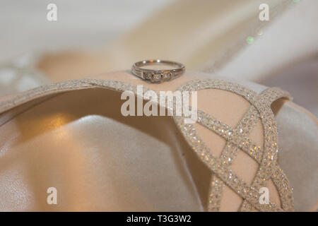 Engagement ring, close up,  sitting on the side of a brides' sparkly shoe on her wedding day Stock Photo
