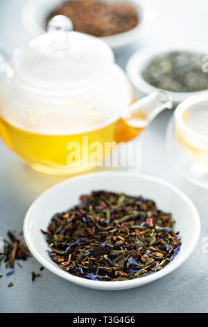 Green loose leaf tea and a teapot Stock Photo