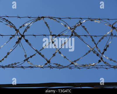 Barbed wire fence in the blue sky Stock Photo