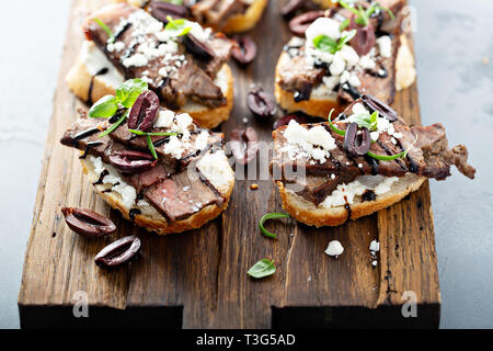 Steak bruschetta with feta and olives Stock Photo