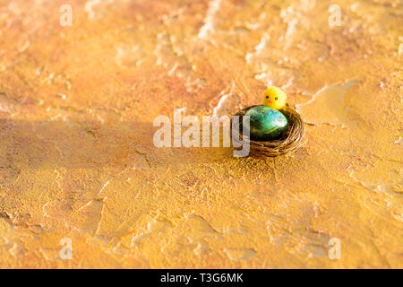 Composition with Easter eggs in nest, on orange background. Easter Egg with copy space for text.Happy Easter greeting card. an invitation to celebrate Stock Photo