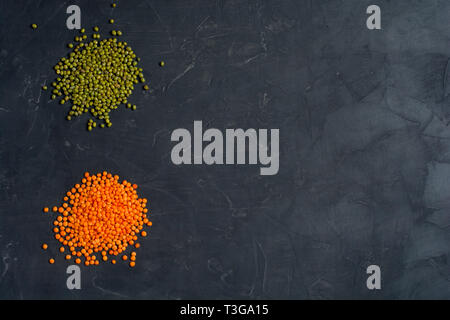 Top view of natural cereal food consisted of red and green lentils beans on dark background. Healthy food concept. Stock Photo