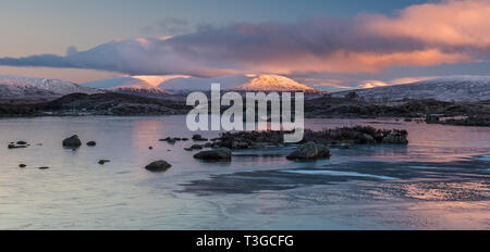 Sunrise over a frozen Lochan na h-achlaise on Rannoch Moor near the enterance to Glencoe in the Scottish Highlands Stock Photo