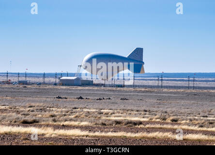 Aerostat surveillance blimp with downward-looking radar for drug smugglers aircraft detection, low on ground due to strong winds, near Marfa, Texas Stock Photo