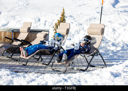 Happy people, children and adults, skiing on a sunny day in Tyrol mountains. Kids having fun while skiing Stock Photo