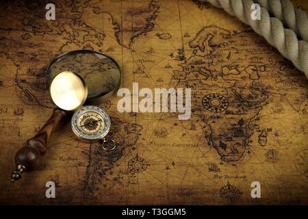 Vintage Compass and magnifying glass lies on an ancient world map ...
