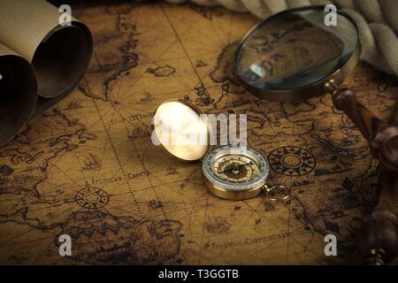 Vintage Compass and magnifying glass lies on an ancient world map ...