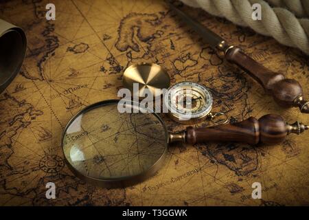 Vintage Compass and magnifying glass lies on an ancient world map ...