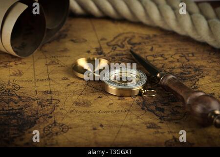 Vintage Compass lies on an ancient world map - adventure stories background Stock Photo