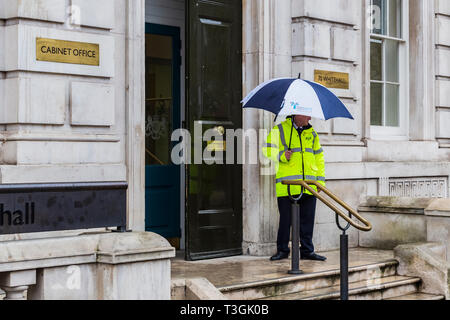 Security Guard with Umbrella Outside the Cabinet Offices on Whitehall in London Stock Photo