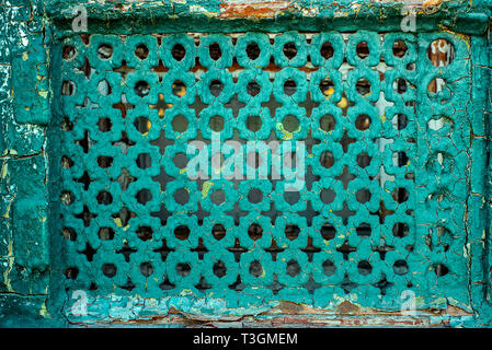 Shabby Iron Old Grille On Emergency Window. Iron Sheet With Different Geometric Holes Painted By Blue Cracked Paint. Stock Photo