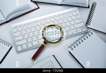 magnifying glass on the pc keyboard search technology concept Stock Photo