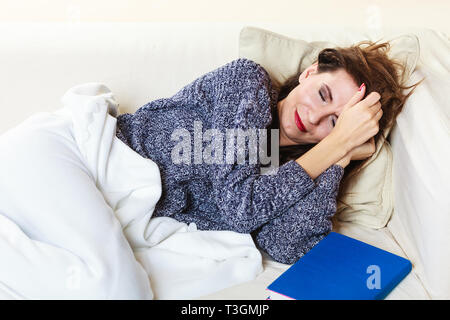 Health balance sleep deprivation concept. Woman lying on couch suffering from head pain taking power nap Stock Photo