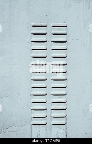 Two rows of perforated air vents on steel door in switchboard. Stock Photo