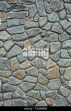 Wall from rubble stone of gray color. Decorative texture uneven wall surface from real stone. Stock Photo