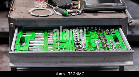 set of wrenches in a plastic stand in a drawer of a nightstand in a car repair shop Stock Photo