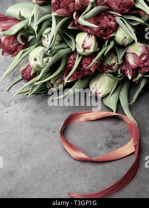 9 May background - red tulips bunch and red ribbon on the concrete background, free space for text Stock Photo