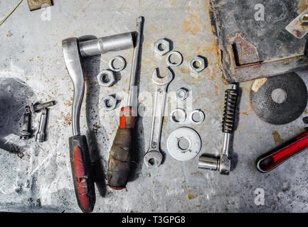 Old tools, wrenches, screwdriver, nuts, lie on a metal table, workshop, repair Stock Photo