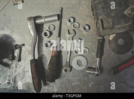 Old tools, wrenches, screwdriver, nuts, lie on a metal table, workshop, repair Stock Photo