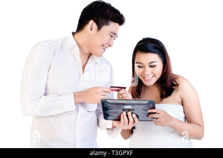 Man and his pregnant wife shopping online using digital tablet Stock Photo