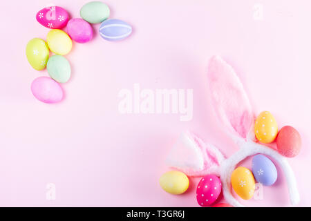 Easter rabbit flaffy ears and colored easter colored eggs on pink and