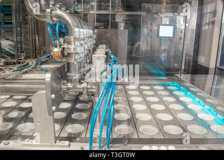 unit for pouring yoghurt into plastic jars at a dairy factory Stock Photo