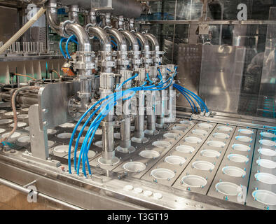 unit for pouring yoghurt into plastic jars at a dairy factory Stock Photo