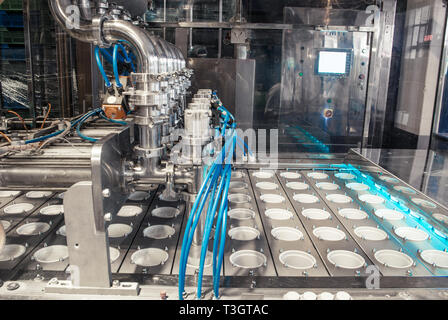 unit for pouring yogurt into plastic jars at a dairy factory Stock Photo