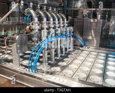 unit for pouring yogurt into plastic jars at a dairy factory Stock Photo