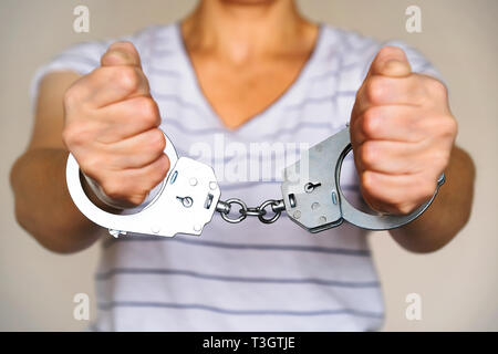 Detained woman at the police station. Handcuffs on the wrists of the detainee Stock Photo