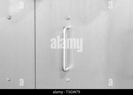 Metal handle on metal door in stainless steel Stock Photo