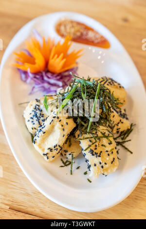 deep fried organic tofu topping with organic black sesame seaweed and leek. Thai Chinese organic street food and cuisine. Stock Photo