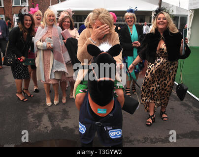 Racegoers on mechanical horses during Ladies Day of the 2019 Randox Health Grand National Festival at Aintree Racecourse. Stock Photo