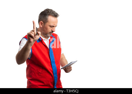 Busy hypermarket or supermarket male employee making wait gesture with index finger as looking at notes isolated on white background Stock Photo